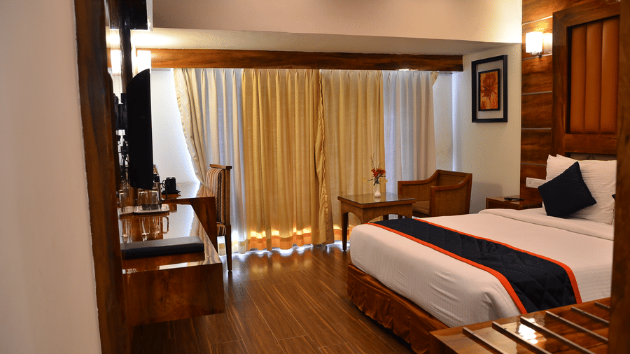 A premium room featuring balcony access, cosy lighting, and wooden flooring for a classy ambience - Benzz Park, Kodaikanal