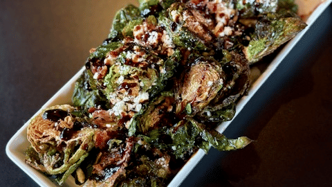 A rectangular dish filled with a flavorful roasted vegetable and chicken preparation served at Kit Carson Lodge