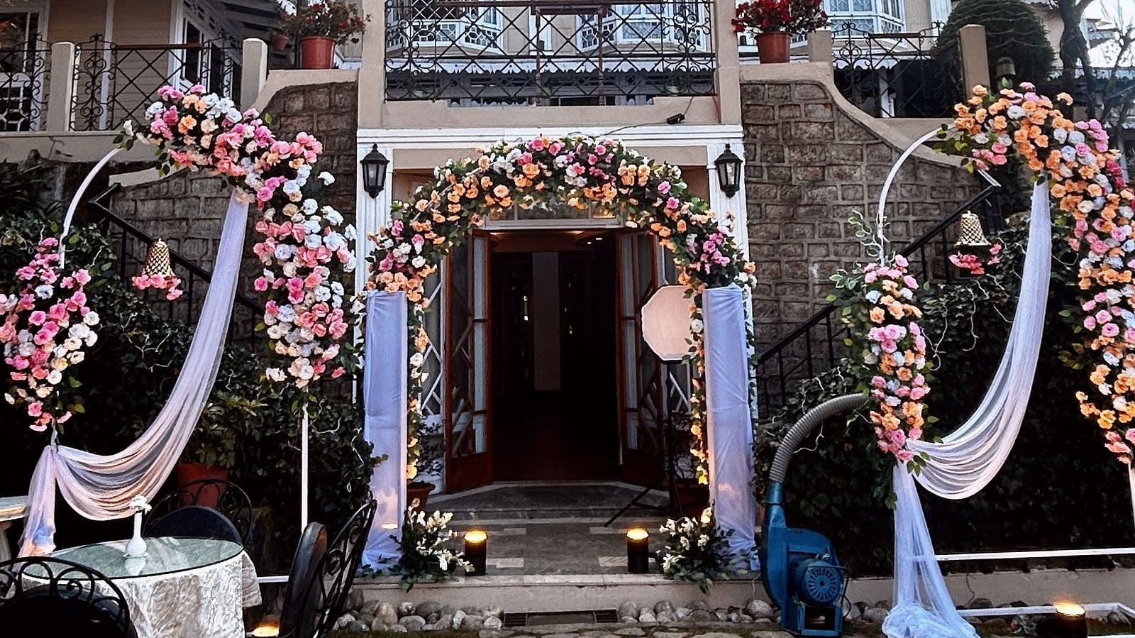 Wedding celebrations at Cedar Inn, Darjeeling, highlighting outdoor seating and traditional decor in front of the hotel façade.