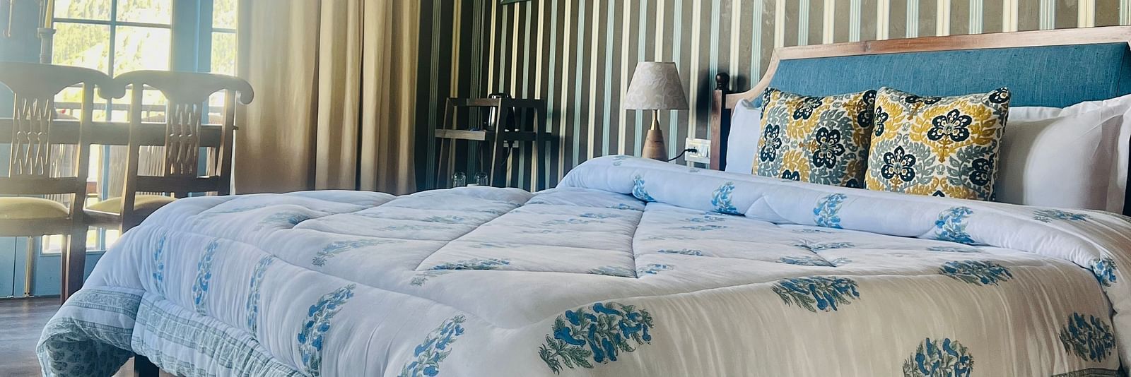 Side view of Luxury Cottage with bed and a photo frame above the bed | Faraway Cottages, Auli