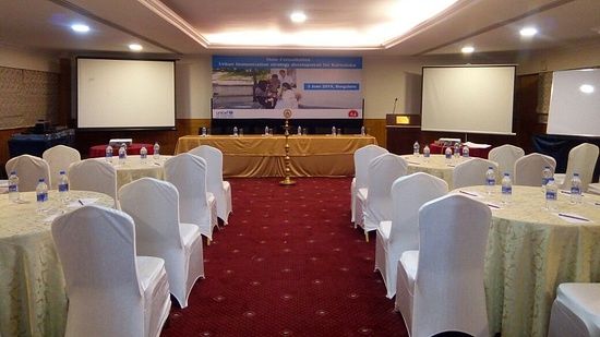 A banquet with seats arranged in inauguration setup, portraying a lamp on the stage - Monarch Hotels