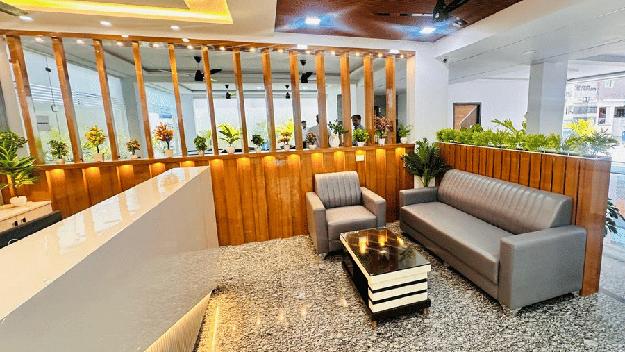 Hotel reception desk with a seating area featuring a sofa, armchair, and coffee table | Hotel Aurora Bliss