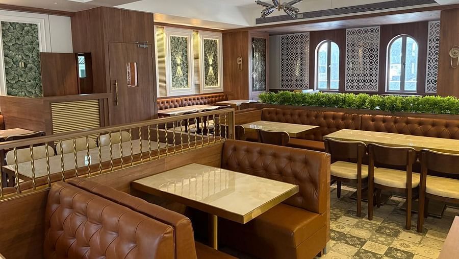 A warmly lit dining area with booth seating and wooden tables - Melior Inn