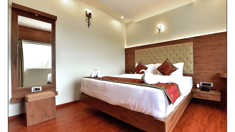 Royal Lotus View Resotel, Bangalore Bengaluru full view of standard room featuring a queen size bed and room amenities like a television a wardrobe etc. along with floor to ceiling windows - Royal Lotus View Resotel2