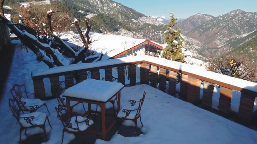 Snow terrace outside the dining hall with a scenic mountain view in the background on a sunny day - Ramgarh Bungalows, Nainital.