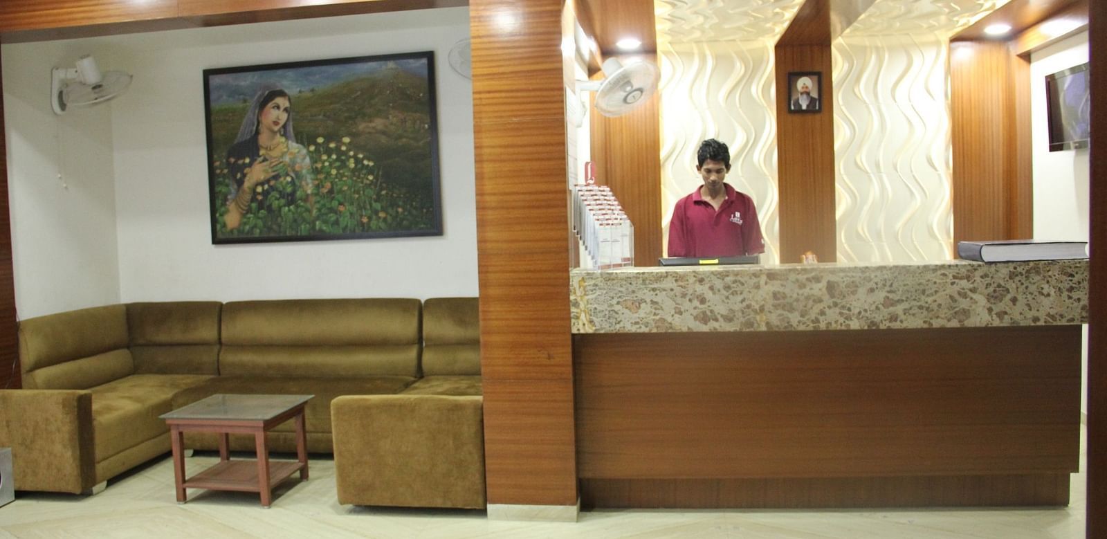 Hotel reception area with staff and wall art in the background