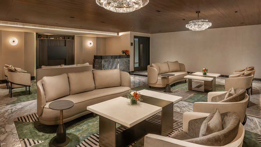 Lounge area of the Experience Centre with comfortable beige sofas, marble coffee tables, and contemporary lighting at The Residency Towers Chennai.
