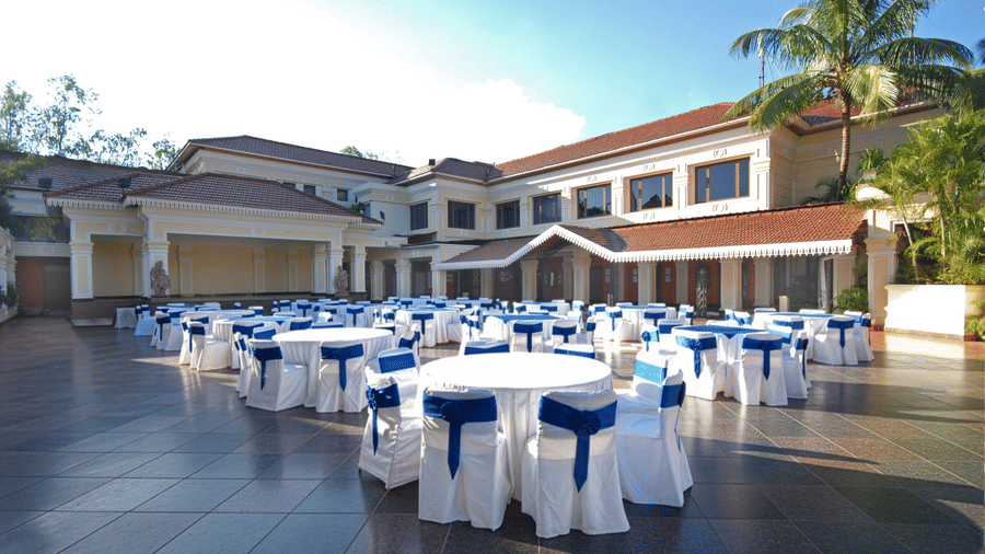 Open-air wedding mandap venue at Mayfair Lagoon Bhubaneswar with white chair arrangements and tropical garden surroundings