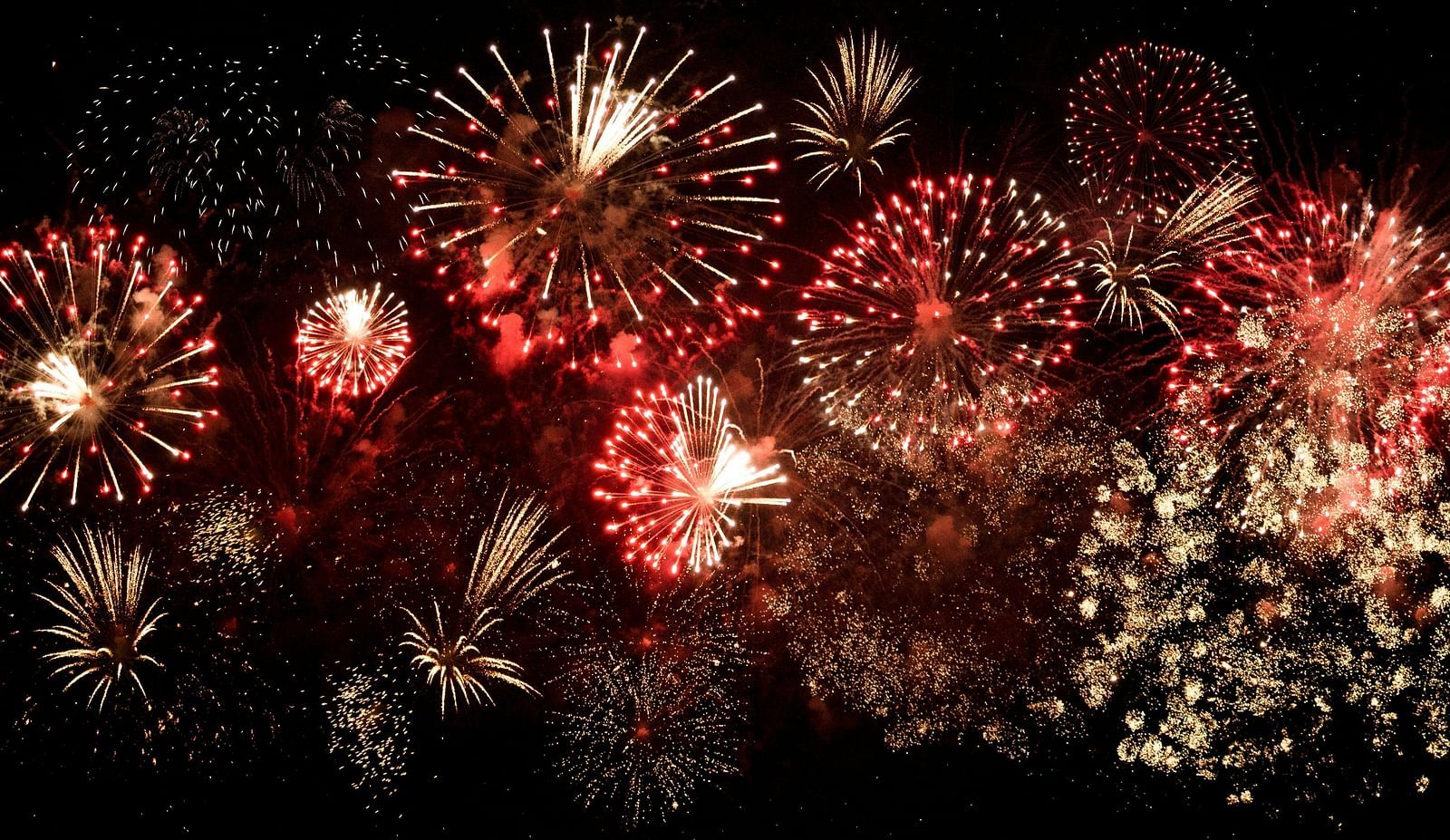 An overview of the sky with many fireworks bursting in the sky