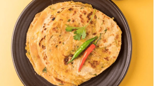 Deo Bagh - 17th Century, Gwalior - a black plate serving paratha along with sauce