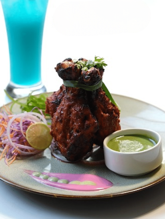 A plate with meat, salad, and a drink, presented on a table at Cenneys Gateway.
