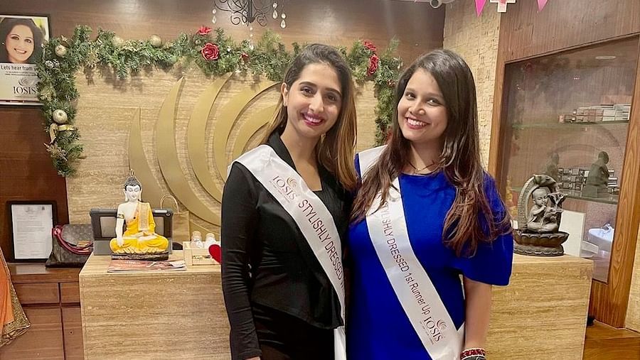 Two ladies standing in front of reception of IOSIS