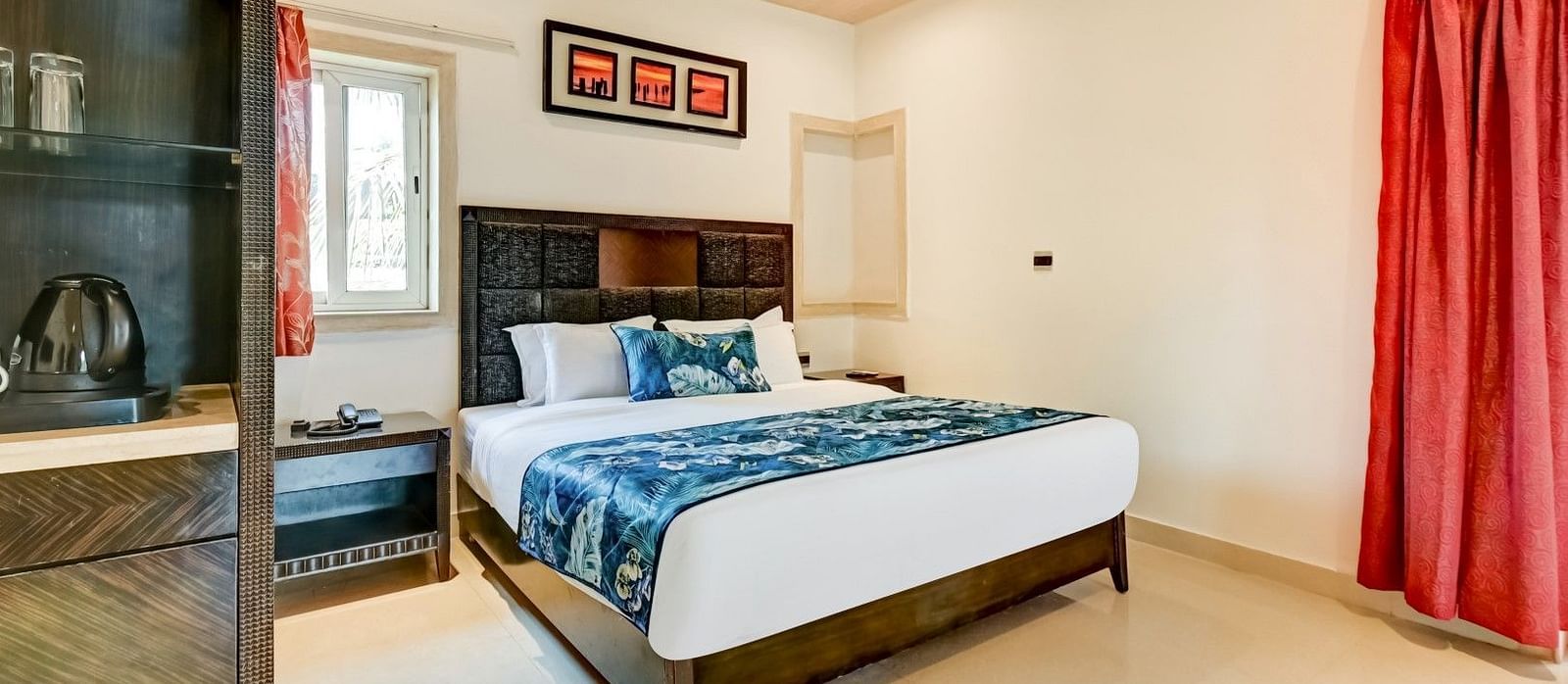  Generously sized bed accompanied by two wooden bedside tables and a large wooden wardrobe