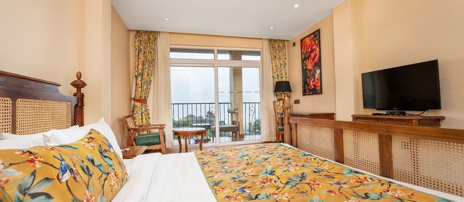 A room at Summit Barsana Resort & Spa, Kalimpong with a double bed, a television and large windows