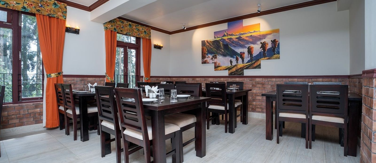 Image of a dining room with tables and chairs and large poster on the wall at Summit Sherpa Mountain Hotel & Spa, Kalimpong
