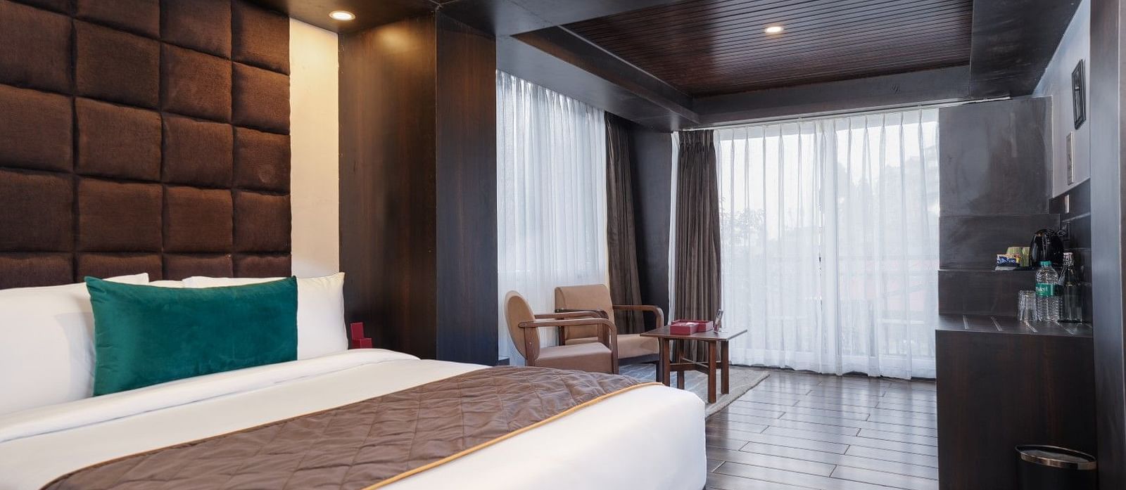 Image of a room that is well furnished with a king size bed and also has an access to a private balcony