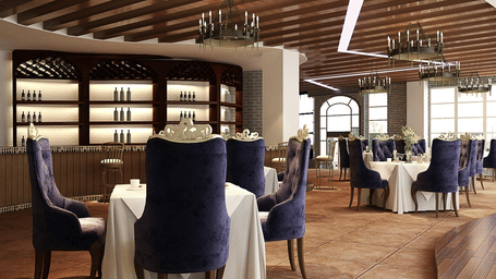 A restaurant interior with plush blue velvet chairs, white tablecloths, and a wooden panelled ceiling with modern light fixtures.