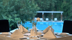 a dining table in front of the pool
