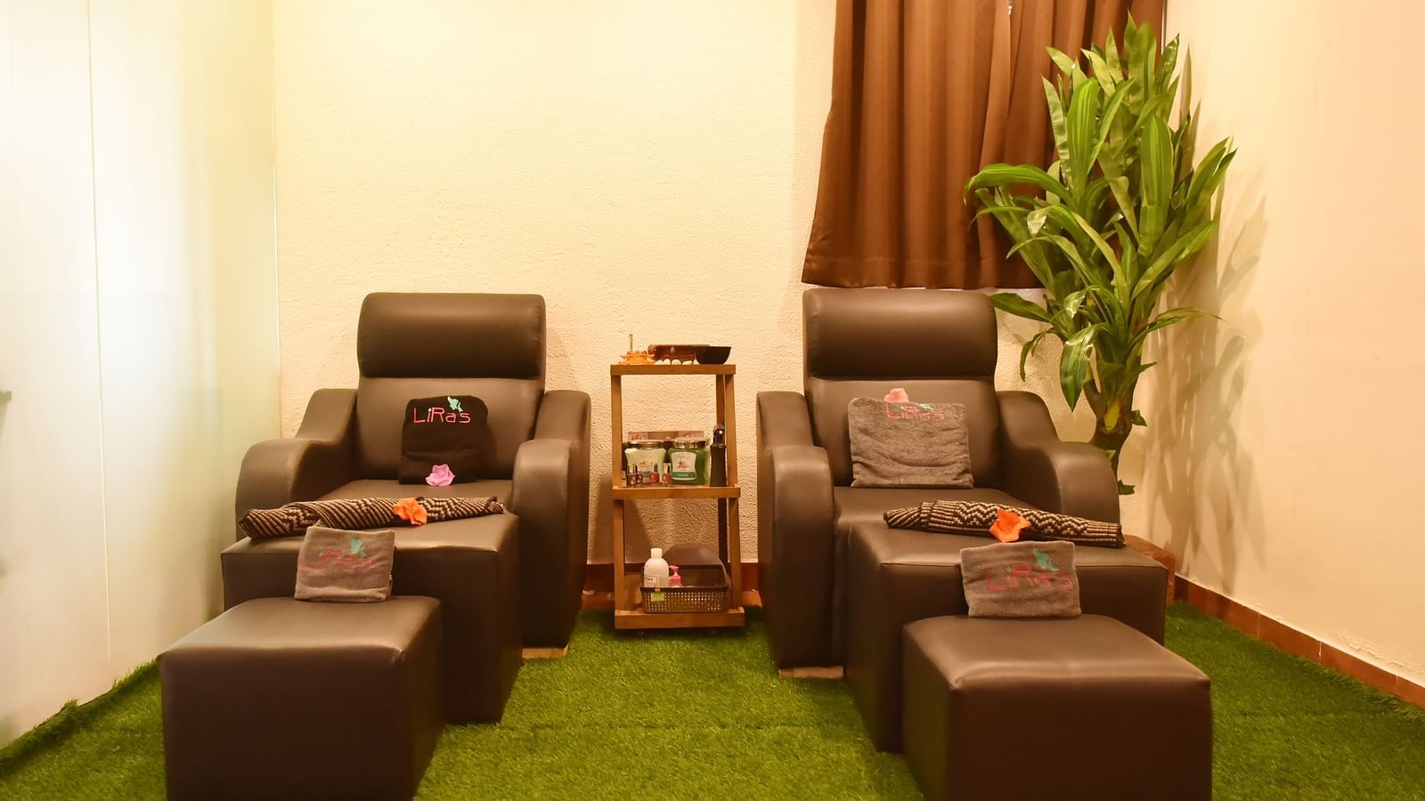 Two comfortable massage chairs with footrests in a relaxing spa setting at Forest Escape, with plants and soft lighting.