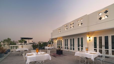 An open-air rooftop dining arrangement at Dileep Kothi, Jaipur