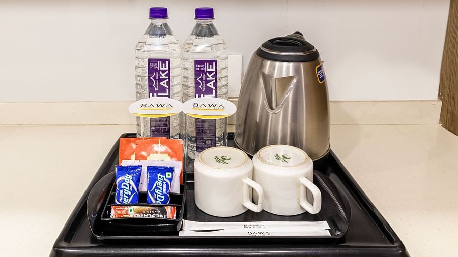 Tea and coffee setup along with water bottles placed in a tray at Hotel Bawa, Gurgaon.