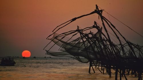 an evening view of Chinese fishing nets with the sun setting in the background