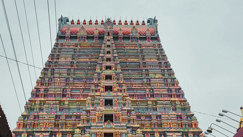 A majestic temple gopuram towers upwards, adorned with colourful sculptures and flanked by power lines, it is one of the famous temple in Pollachi.