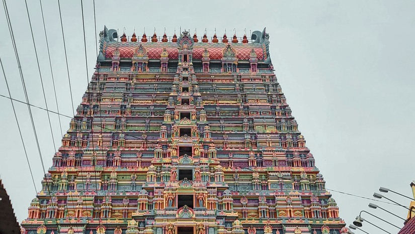 A majestic temple gopuram towers upwards, adorned with colourful sculptures and flanked by power lines, it is one of the famous temple in Pollachi.