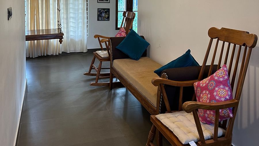 Two rocking chairs and a small couch kept in the common area at Ananda Holiday Home, Wayanad 3