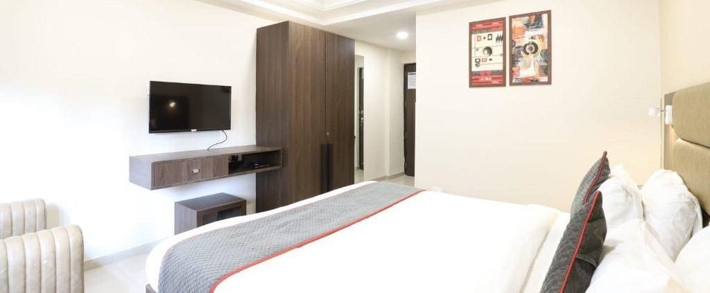 Corner view shot of the Premium Room featuring a double bed with a grey bed runner spread over it at Pravasa Ahmedabad.