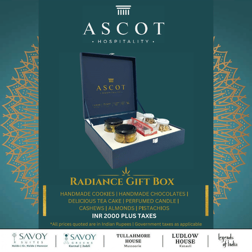 Ascot-branded box labeled Radiance Gift Box with traditional sweets and decor items, set against an elegant teal background with gold geometric patterns, representing premium festive gifting by Ascot.
