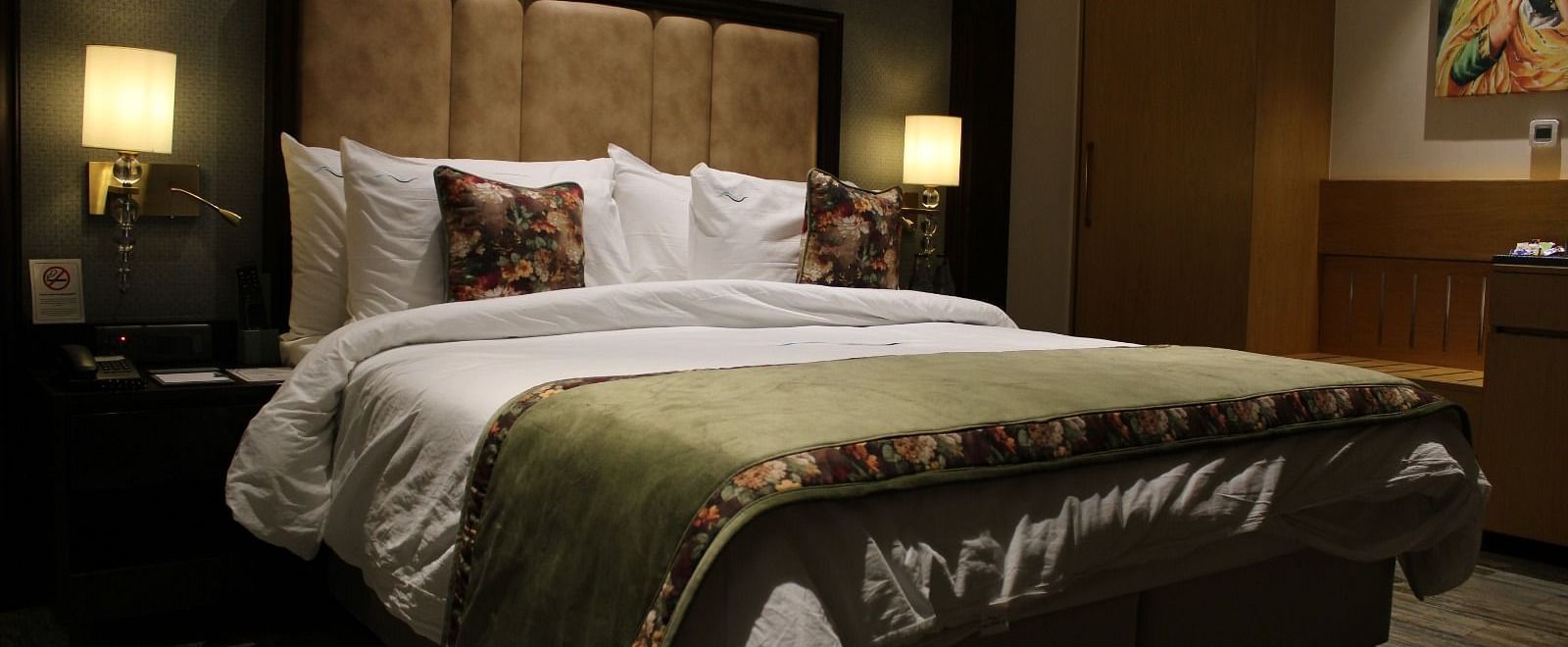 A room with a king size bed, patterned headboard, and lamps at BluSalzz Residence, Amritsar