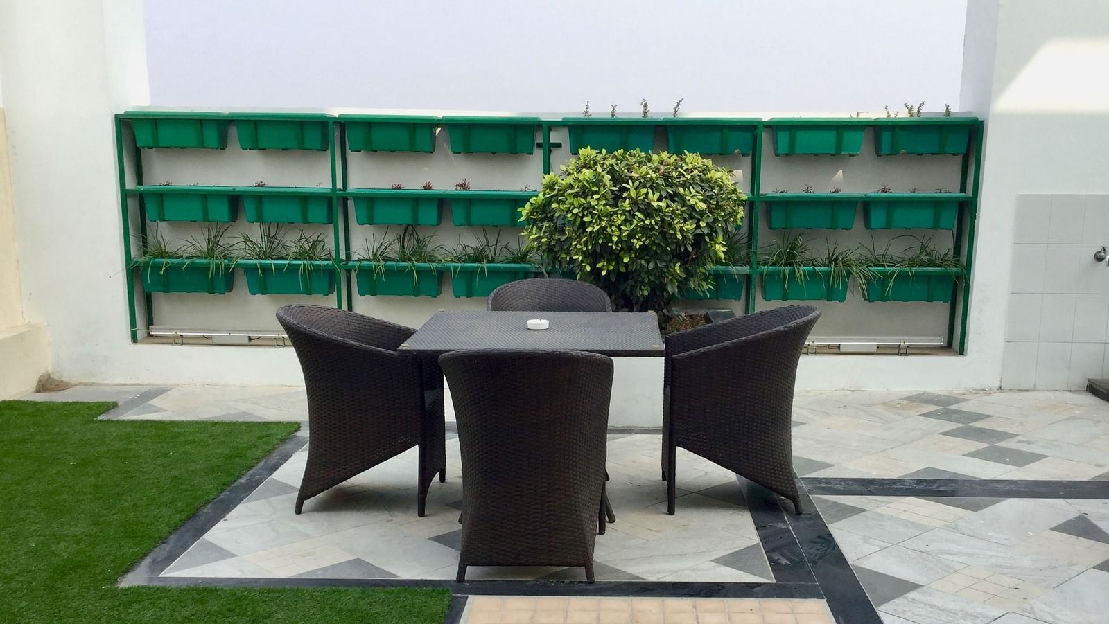 A beautiful open terrace featuring a common seating area with three chairs surrounding a table - Ramada by Wyndham, Ghaziabad, Vasundhara