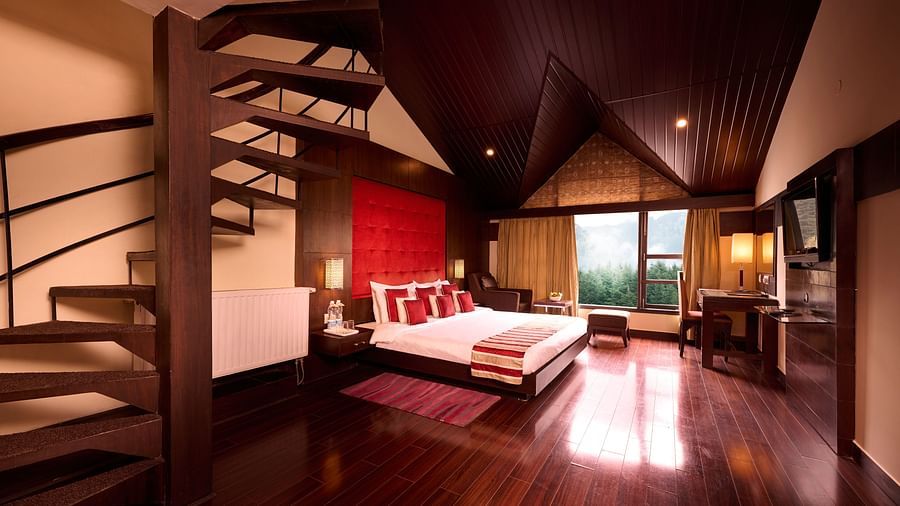 Renest Hotel Manali - Interior view of the Pelican suite featuring a king size bed and a staircase leading to another floor 