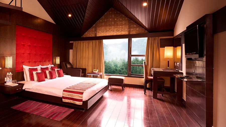 Renest Hotel Manali -Interior view of the Pelican suite featuring a king size bed in red, white and brown decor 