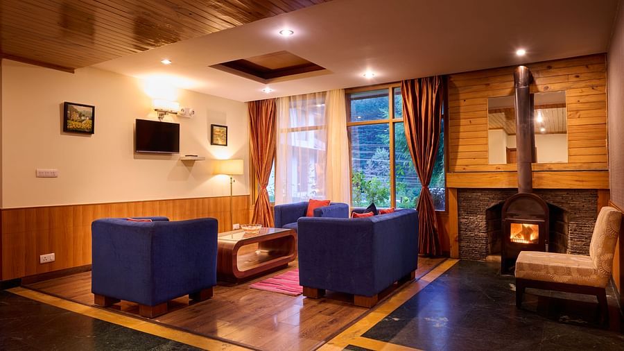 Renest Manali - interior view of the living room featuring blue coloured sofas 