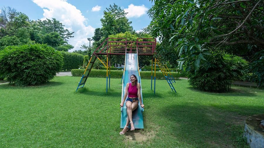 A woman enjoying a slide in the outdoor play area at The Tattwaa Corbett Spa & Resort.