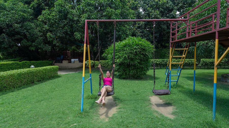 Woman on a swing set in the play area at The Tattwaa Corbett Spa & Resort.