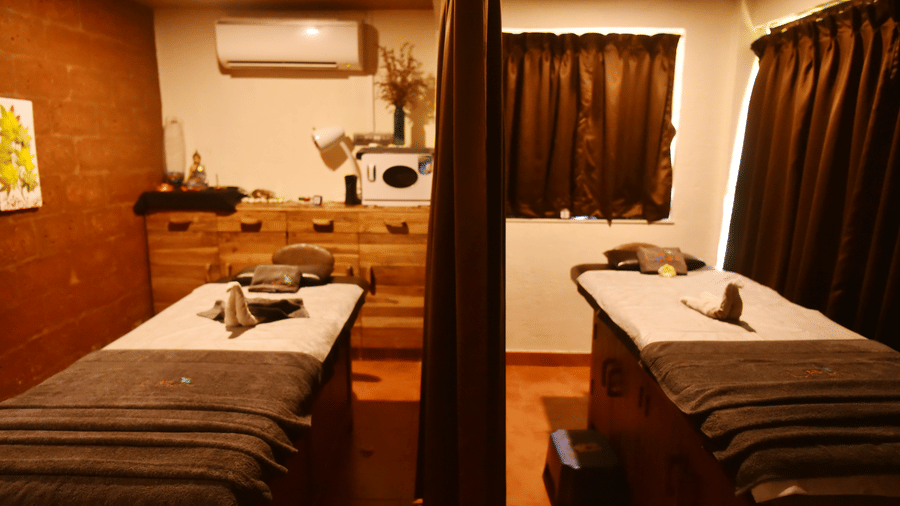 A brightly lit spa treatment room at Forest Escape, with two massage beds and essential equipment.