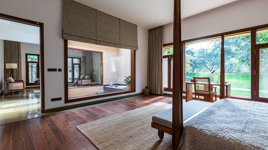 Bedroom with a wooden bed, large windows, rug, indoor space - Shreyas Retreat