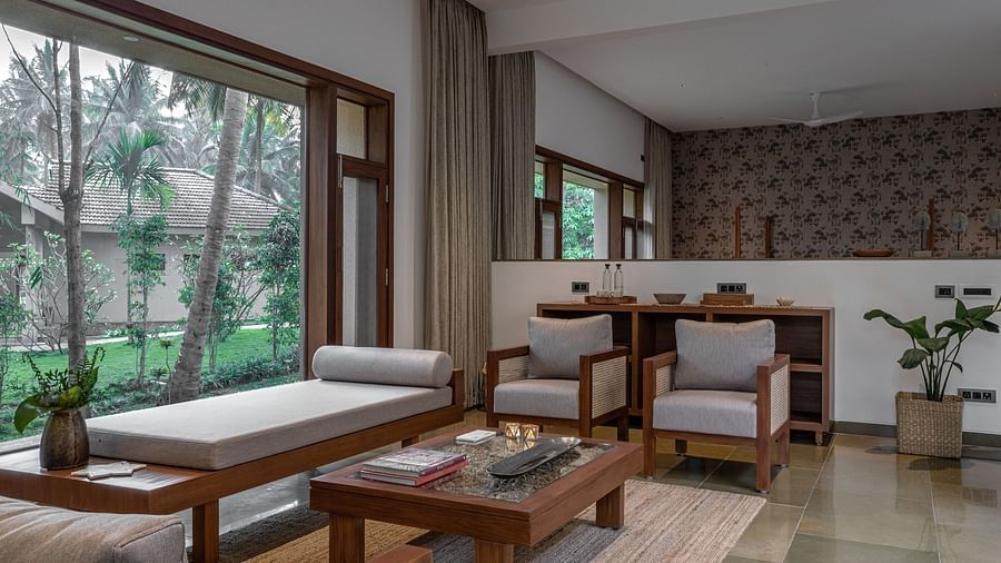Interior room with a couch, chairs, and a table, natural light, modern design - Shreyas Retreat
