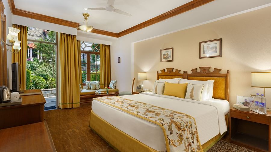 A full view of a garden facing room with a bed -the naini retreat, nainital.