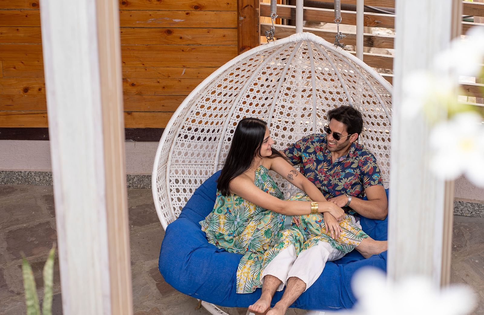 Two people sitting in a hanging chair or swing.