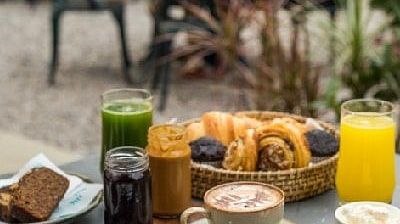 Breakfast spread on an outdoor table at Karma Chalets with eggs, toast, baked goods, juice, and fruit.
