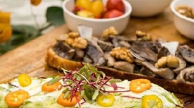 Toasted open sandwich with vegetables and mushrooms, served with condiments and a side of watermelon at Karma Chalets..