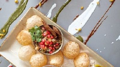 Top view of assorted Indian snacks and tea served on a white tray with sauces at Karma Chalets.