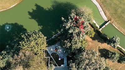 An aerial view of the luxury villa with trees surrounding it - Karma Lakelands