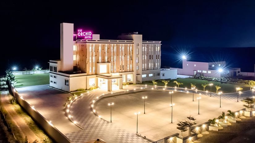 Facade image of The Orchid Hotel, Jamnagar in the night with the lights on 