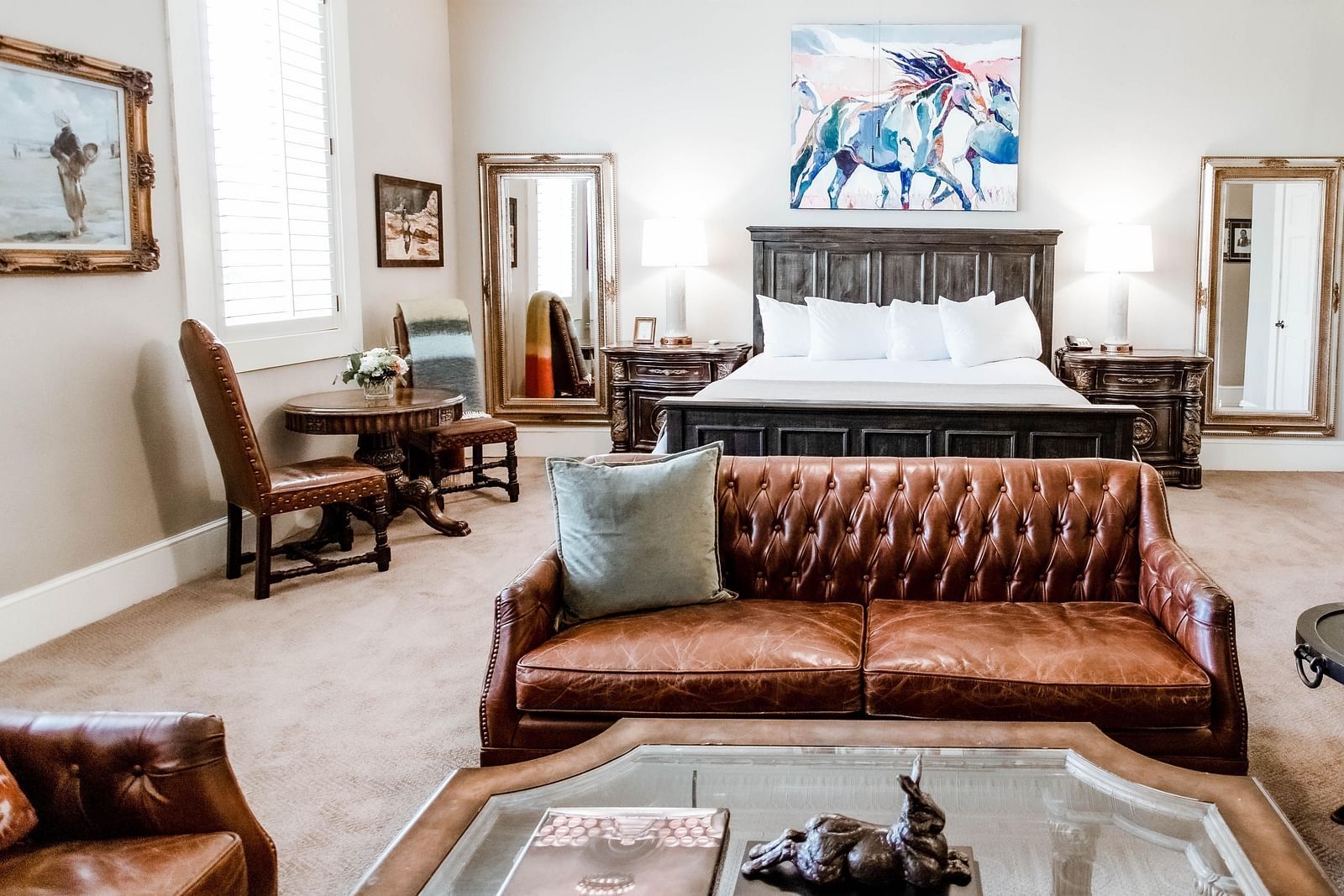 A luxurious bedroom featuring a leather sofa, wooden furniture, and stylish accents, designed for comfort and sophistication - The Grand Hotel & Ballroom, McKinney