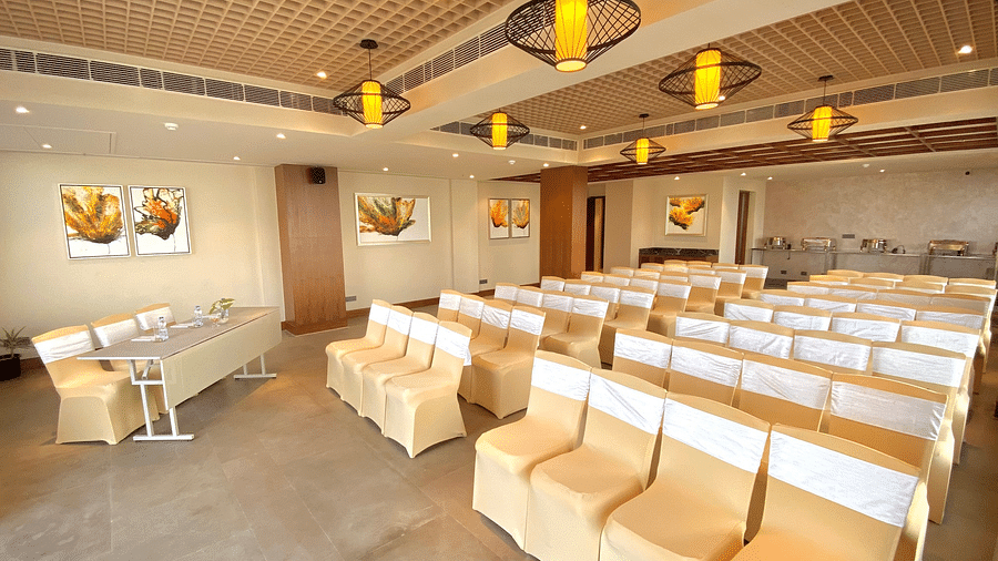 An image of a banquet hall with its seating arrangement and subtle decoration with lighting - Hideaway banquets & Lawns, Greater Noida